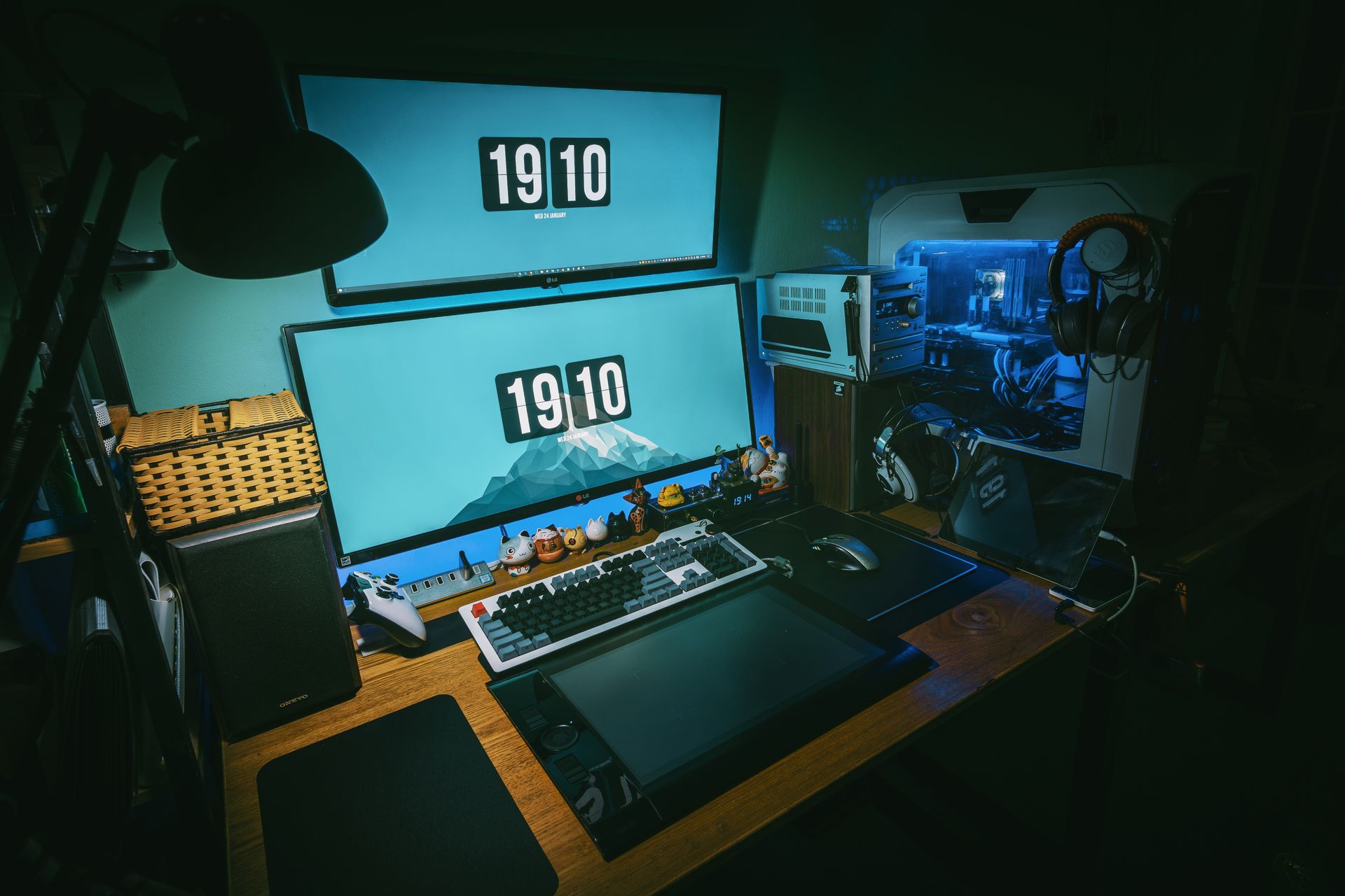 An ordered dual-monitor desk setup glowing in a dim room at night