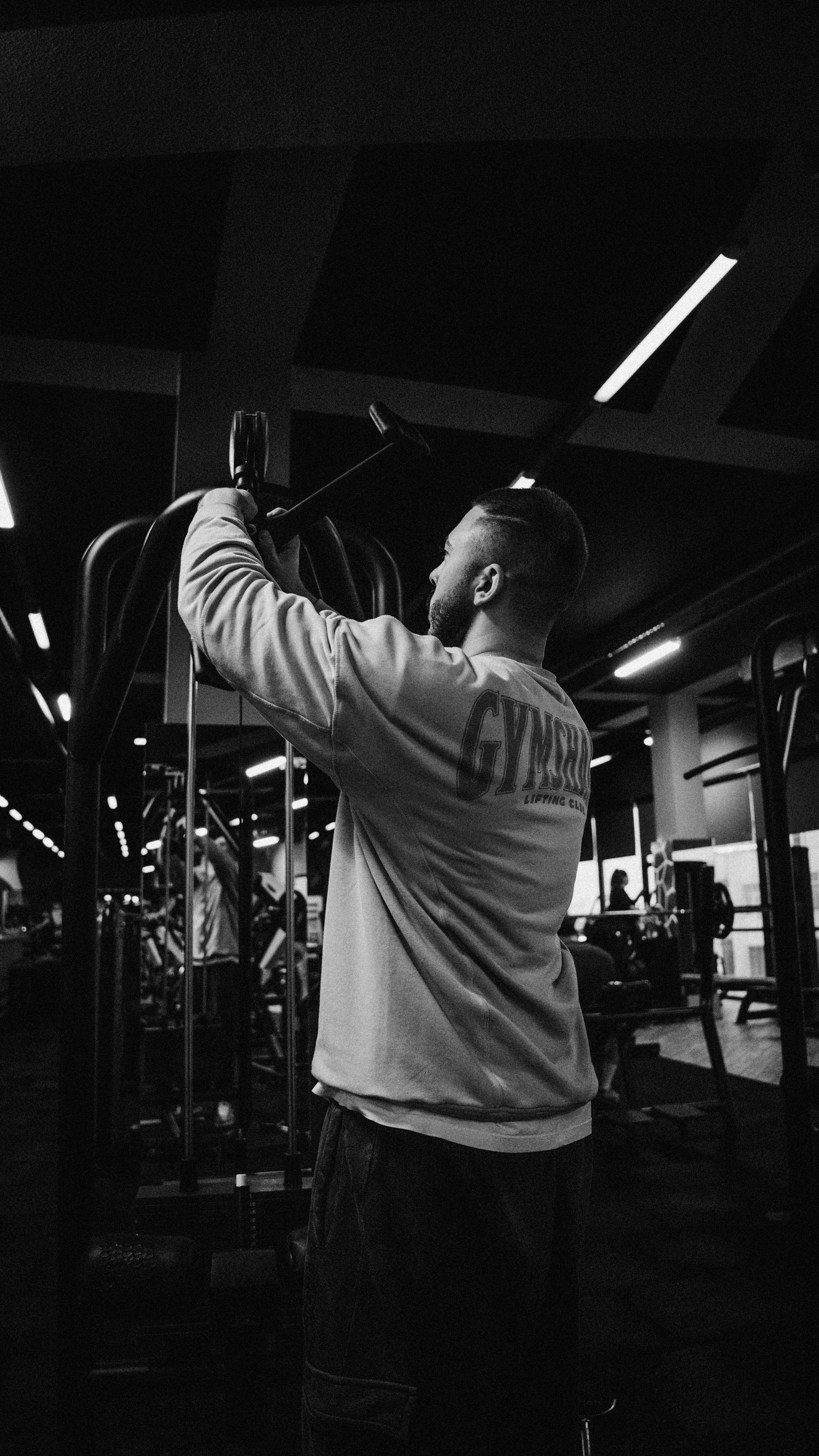 A man training alone with gym equipment in high-contrast black and white